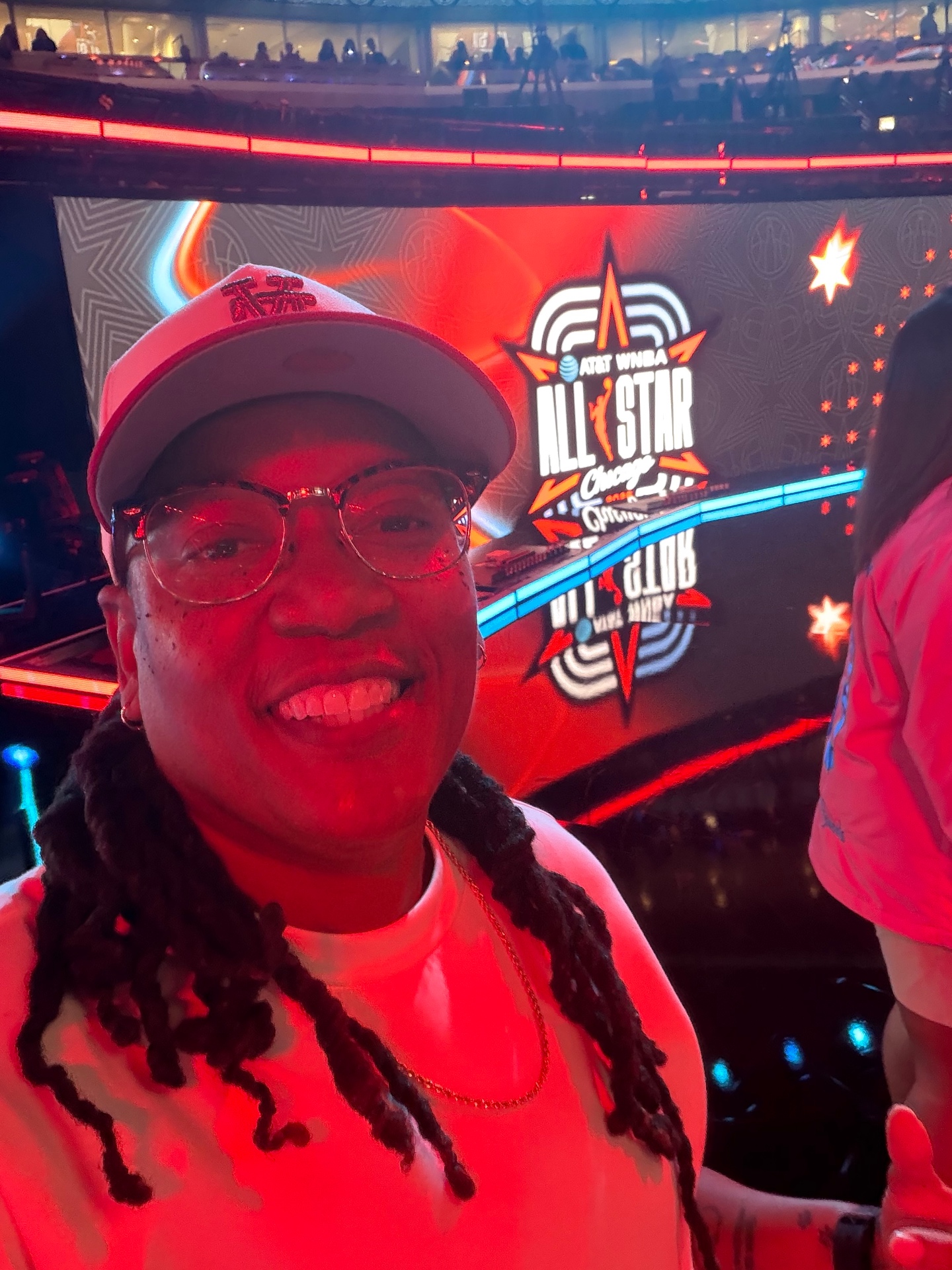 Community member smiling courtside at an All-Star event